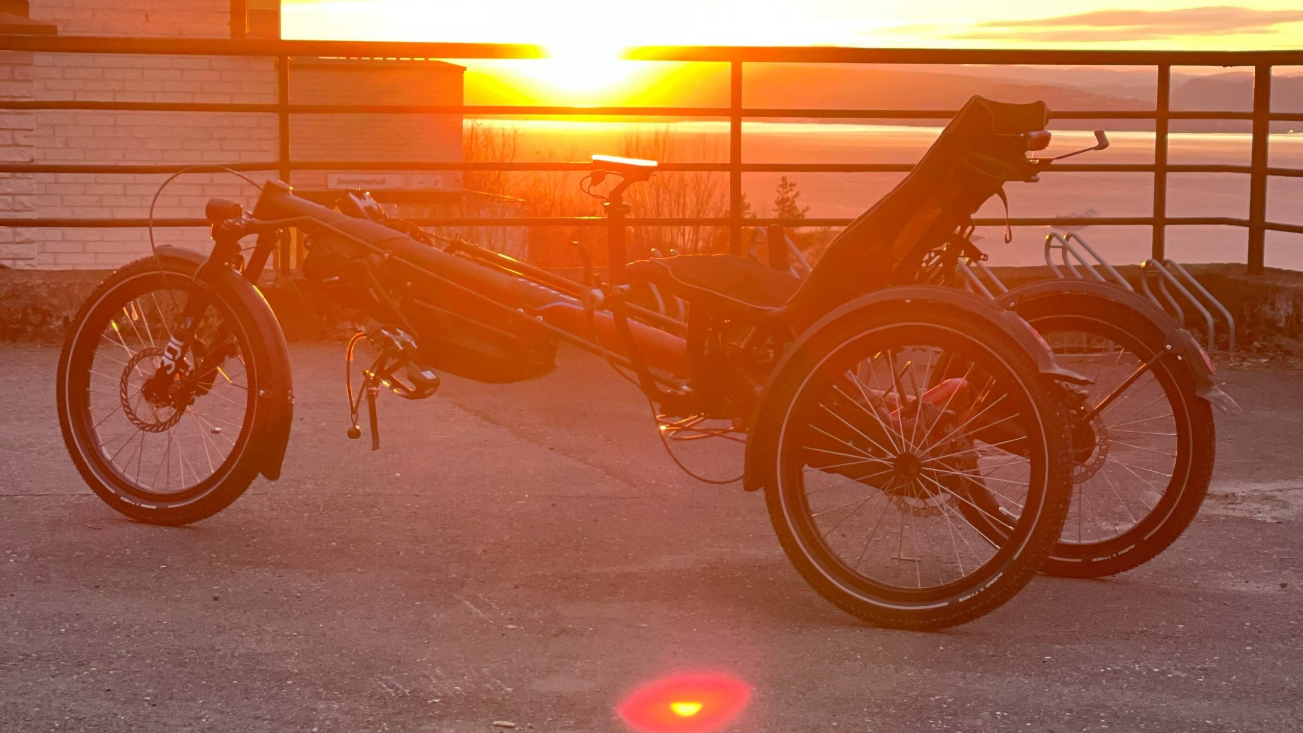 en trehjuls liggesykkel i solnedgang